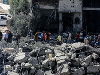 Palestinians are walking on the rubble of destroyed buildings following operations by the Israeli Special Forces in the Nuseirat camp, in th...