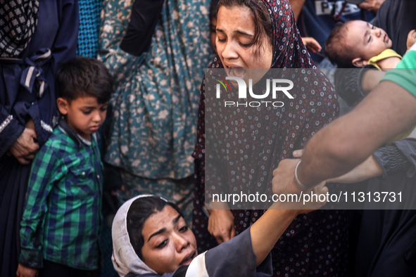 A mourner is reacting during the funeral of Palestinians killed in Israeli strikes, amid the Israel-Hamas conflict, in Deir Al-Balah, in cen...