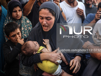 A mourner is reacting during the funeral of Palestinians killed in Israeli strikes, amid the Israel-Hamas conflict, in Deir Al-Balah, in cen...