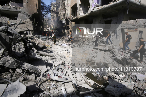 Palestinians are walking on the rubble of destroyed buildings following operations by the Israeli Special Forces in the Nuseirat camp, in th...