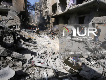 Palestinians are walking on the rubble of destroyed buildings following operations by the Israeli Special Forces in the Nuseirat camp, in th...