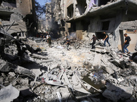 Palestinians are walking on the rubble of destroyed buildings following operations by the Israeli Special Forces in the Nuseirat camp, in th...