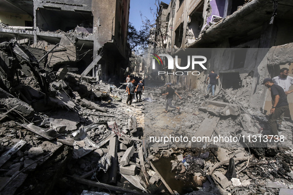 Palestinians are walking on the rubble of destroyed buildings following operations by the Israeli Special Forces in the Nuseirat camp, in th...