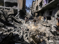 Palestinians are walking on the rubble of destroyed buildings following operations by the Israeli Special Forces in the Nuseirat camp, in th...