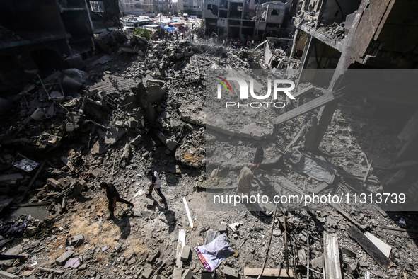 Palestinians are walking on the rubble of destroyed buildings following operations by the Israeli Special Forces in the Nuseirat camp, in th...