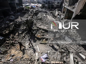 Palestinians are walking on the rubble of destroyed buildings following operations by the Israeli Special Forces in the Nuseirat camp, in th...