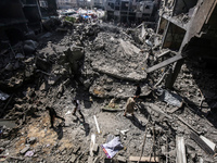 Palestinians are walking on the rubble of destroyed buildings following operations by the Israeli Special Forces in the Nuseirat camp, in th...