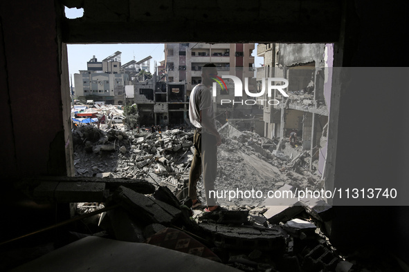 Palestinians are walking on the rubble of destroyed buildings following operations by the Israeli Special Forces in the Nuseirat camp, in th...