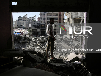 Palestinians are walking on the rubble of destroyed buildings following operations by the Israeli Special Forces in the Nuseirat camp, in th...