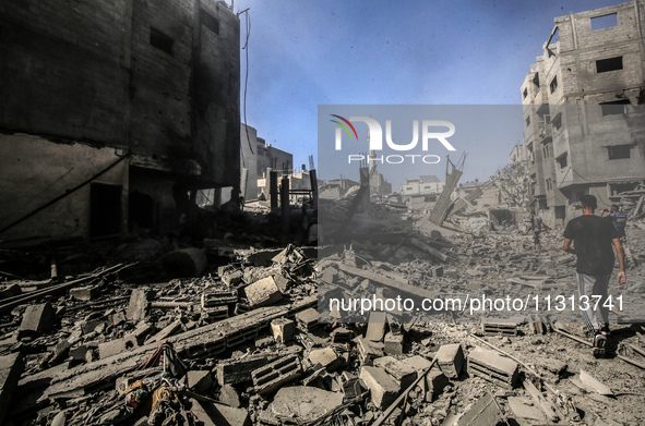 Palestinians are walking on the rubble of destroyed buildings following operations by the Israeli Special Forces in the Nuseirat camp, in th...