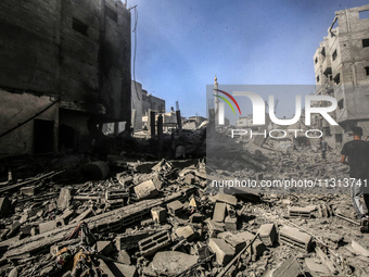 Palestinians are walking on the rubble of destroyed buildings following operations by the Israeli Special Forces in the Nuseirat camp, in th...