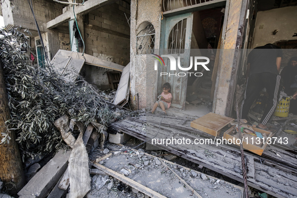 Palestinians are standing on the rubble of destroyed buildings following operations by the Israeli Special Forces in the Nuseirat camp, in t...