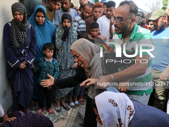 A mourner is reacting during the funeral of Palestinians killed in Israeli strikes, amid the Israel-Hamas conflict, in Deir Al-Balah, in cen...