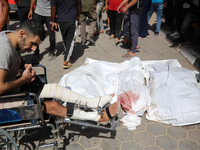 Palestinians are mourning over the bodies of victims of Israeli bombardment outside a hospital in Deir el-Balah in the central Gaza Strip, o...