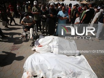 Palestinians are mourning over the bodies of victims of Israeli bombardment outside a hospital in Deir el-Balah in the central Gaza Strip, o...