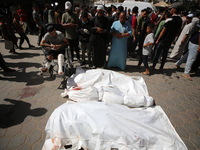 Palestinians are mourning over the bodies of victims of Israeli bombardment outside a hospital in Deir el-Balah in the central Gaza Strip, o...