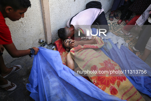 A mourner is reacting during the funeral of Palestinians killed in Israeli strikes, amid the Israel-Hamas conflict, in Deir Al-Balah, in cen...