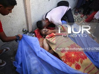 A mourner is reacting during the funeral of Palestinians killed in Israeli strikes, amid the Israel-Hamas conflict, in Deir Al-Balah, in cen...