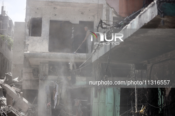 Palestinians are inspecting the damage and debris a day after an operation by the Israeli Special Forces in the Nuseirat camp, in the centra...