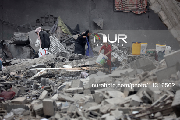 Palestinians are inspecting the damage and debris a day after an operation by the Israeli Special Forces in the Nuseirat camp, in the centra...