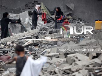 Palestinians are inspecting the damage and debris a day after an operation by the Israeli Special Forces in the Nuseirat camp, in the centra...