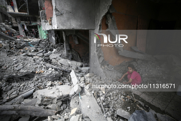 A Palestinian girl is searching through the rubble of their home a day after an operation by the Israeli Special Forces in the Nuseirat camp...