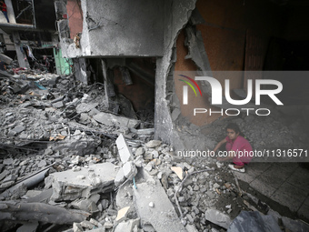 A Palestinian girl is searching through the rubble of their home a day after an operation by the Israeli Special Forces in the Nuseirat camp...