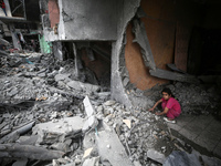 A Palestinian girl is searching through the rubble of their home a day after an operation by the Israeli Special Forces in the Nuseirat camp...