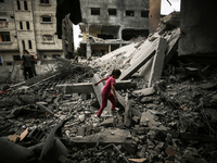 A Palestinian girl is walking over debris to get to a building a day after an operation by the Israeli Special Forces in the Nuseirat camp,...