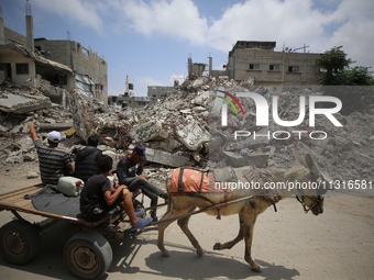 Palestinians are walking past debris a day after an operation by the Israeli Special Forces in the Nuseirat camp, in the central Gaza Strip,...