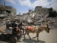 Palestinians are walking past debris a day after an operation by the Israeli Special Forces in the Nuseirat camp, in the central Gaza Strip,...