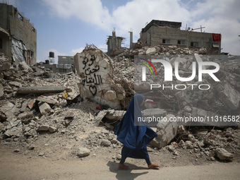 Palestinians are walking past debris a day after an operation by the Israeli Special Forces in the Nuseirat camp, in the central Gaza Strip,...