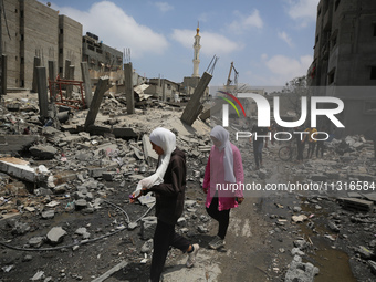 Palestinians are walking past debris a day after an operation by the Israeli Special Forces in the Nuseirat camp, in the central Gaza Strip,...