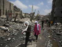 Palestinians are walking past debris a day after an operation by the Israeli Special Forces in the Nuseirat camp, in the central Gaza Strip,...