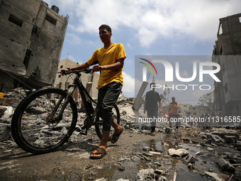 Palestinians are walking past debris a day after an operation by the Israeli Special Forces in the Nuseirat camp, in the central Gaza Strip,...