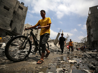 Palestinians are walking past debris a day after an operation by the Israeli Special Forces in the Nuseirat camp, in the central Gaza Strip,...