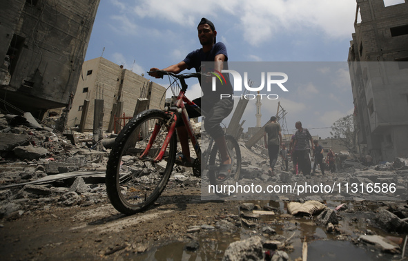 Palestinians are walking past debris a day after an operation by the Israeli Special Forces in the Nuseirat camp, in the central Gaza Strip,...