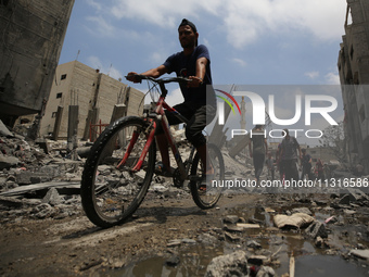 Palestinians are walking past debris a day after an operation by the Israeli Special Forces in the Nuseirat camp, in the central Gaza Strip,...