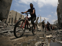 Palestinians are walking past debris a day after an operation by the Israeli Special Forces in the Nuseirat camp, in the central Gaza Strip,...