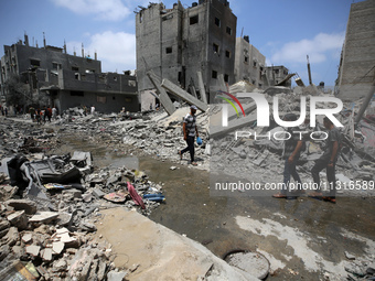 Palestinians are walking past debris a day after an operation by the Israeli Special Forces in the Nuseirat camp, in the central Gaza Strip,...