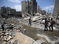 Palestinians are walking past debris a day after an operation by the Israeli Special Forces in the Nuseirat camp, in the central Gaza Strip,...