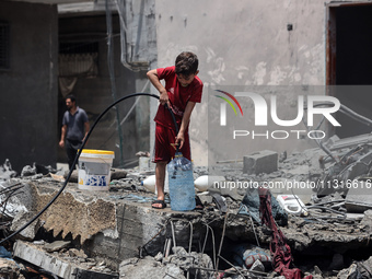 A boy is filling water a day after an operation by the Israeli Special Forces in the Nuseirat camp, in the central Gaza Strip, on June 9, 20...