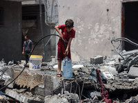 A boy is filling water a day after an operation by the Israeli Special Forces in the Nuseirat camp, in the central Gaza Strip, on June 9, 20...