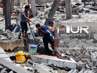 Palestinian children are playing with water amidst a heatwave a day after an operation by the Israeli Special Forces in the Nuseirat camp, i...