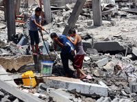 Palestinian children are playing with water amidst a heatwave a day after an operation by the Israeli Special Forces in the Nuseirat camp, i...