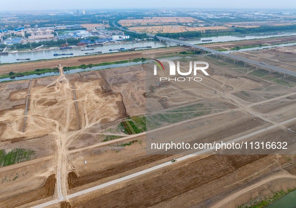 Workers are digging and cleaning the Huaihe River channel at the construction site of the second phase of the Huaihe River Waterway project...