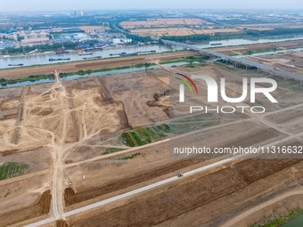 Workers are digging and cleaning the Huaihe River channel at the construction site of the second phase of the Huaihe River Waterway project...