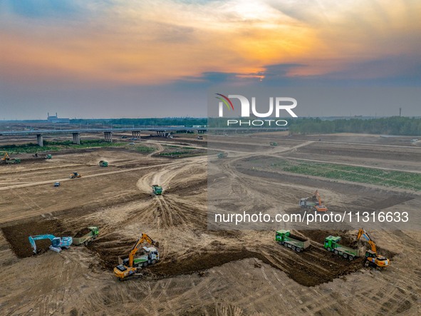 Workers are digging and cleaning the Huaihe River channel at the construction site of the second phase of the Huaihe River Waterway project...