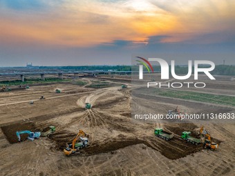 Workers are digging and cleaning the Huaihe River channel at the construction site of the second phase of the Huaihe River Waterway project...