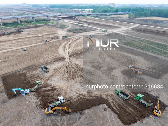 Workers are digging and cleaning the Huaihe River channel at the construction site of the second phase of the Huaihe River Waterway project...